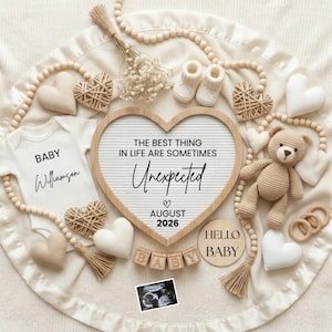 Può includere: Una lavagna a lettere a forma di cuore con il testo THE BEST THING IN LIFE ARE SOMETIMES Unexpected AUGUST 2026, un body bianco per neonati con la scritta BABY Williamson, un orsetto all'uncinetto beige, scarpine bianche, cubi di legno BABY e un'ecografia.