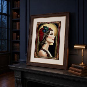 May include: A framed art print featuring a profile portrait of a person wearing a red headpiece adorned with a peacock feather. The subject has dark hair, red lipstick, and a drop earring. The artwork is set within a decorative gold-toned border.