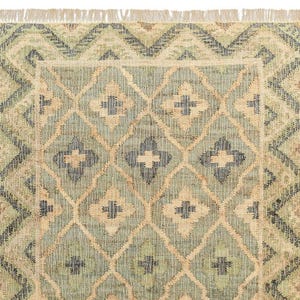 Close-up of the dense flatweave texture showcasing the peachy-tan accents and off-white fringe, an authentic Tapis en jute that is far superior to a lightweight tuft rug, an artificial shining rug, or poorly made hadncrafted rugs.