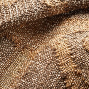 Close-up of the dense flatweave texture showcasing the natural jute diagonal grid and off-white stripes, an authentic Tapis en jute that is far superior to a lightweight tuft rug, an artificial shining rug, or poorly made hadncrafted rugs.