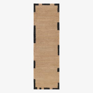May include: A rectangular runner rug featuring a natural tan woven texture. The rug is bordered by a series of distinct, thick black rectangular blocks spaced evenly along the edges, creating a bold contrast against the neutral tan base.