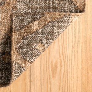 Sunlit room highlighting the rustic charcoal-brown and sandy beige base under modern minimalist furniture, acting as a superior, grounding Cool rugs alternative for eco-conscious interiors without the visual bulk of a heavy victorian rug or a distressed wool rug x12.