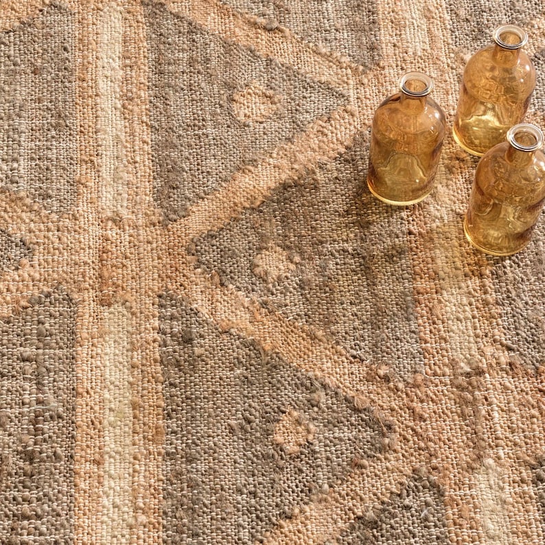 Full overhead perspective of a deep charcoal-brown and golden-tan geometric triangle hand woven flat weave jute rug, a sustainable Naturteppich offering a clean architectural foundation perfect for replacing a massive area rug 14x14 or a generic 10x16 livingroom rug setup.