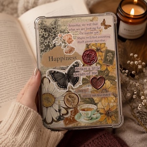 May include: A clear protective tablet case featuring a collage of vintage-style illustrations including yellow sunflowers, white daisies, a butterfly, a teacup, and wax seals. The text reads: Someday, we will find what we are looking for. Or maybe not. Maybe we'll find something much greater than that. Happiness, dream a little dream of me, look up you'll see the stars.