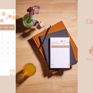 Peut inclure: Une page de calendrier imprimable pour novembre 2026 avec un fond blanc, du texte marron, une mise en page en grille et des illustrations de feuilles d'automne. Le calendrier affiche l'année 2026 et le mois de novembre en haut.