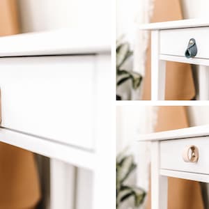 May include: A white bedside table with a drawer and a leather pull handle. The pull is a light beige colour, secured with a gold-coloured rivet. Other images show navy blue and tan leather pull handles.