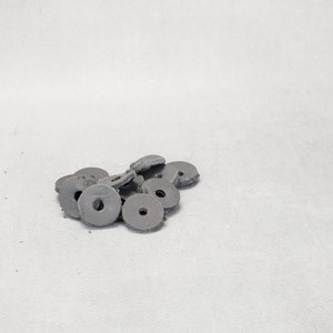 May include: A pile of black rubber washers, likely used for furniture or other household items.