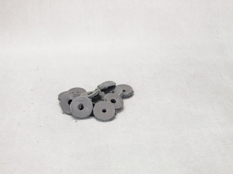 May include: A pile of black rubber washers, likely used for furniture or other household items.