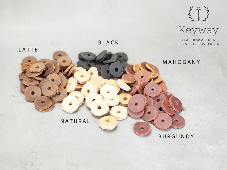May include: Assortment of leather rings in various colors, including black, latte, natural, mahogany, and burgundy. The rings are arranged in a semi-circle on a gray surface. Keyway Hardware & Leatherworks is printed at the top of the image.