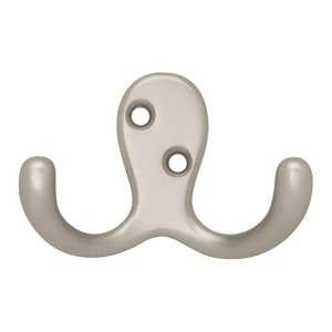 May include: A silver double hook with two rounded hooks. The hook has two screw holes for mounting.
