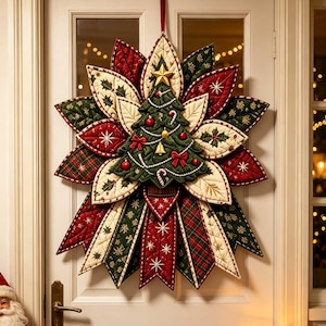 May include: A quilted fabric Christmas wreath featuring a central green tree ornament with gold star, red bows, and candy canes, surrounded by layered, pointed petals in red, green, and cream with holly, plaid, and snowflake patterns.
