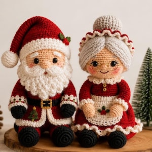 May include: Two handmade crochet dolls representing Santa Claus and Mrs. Claus. Santa wears a red hat with a white pom-pom, a white beard, and a red coat with a black belt. Mrs. Claus has grey hair in a bun, wears glasses, and a red dress with a white apron.