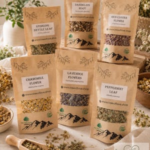 May include: Six brown paper pouches containing dried herbs labeled Stinging Nettle Leaf, Dandelion Root, Red Clover Flower, Chamomile Flower, Lavender Flowers, and Peppermint Leaf, with a small wooden scoop and loose herbs on a light surface.