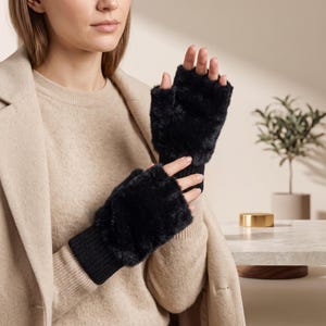May include: A pair of black fingerless gloves featuring a plush, faux fur texture on the back of the hand and a ribbed knit cuff at the wrist. The gloves leave the fingers exposed, providing a combination of warmth and dexterity for the hands.