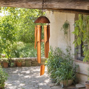 Peut inclure: Un carillon éolien suspendu composé de tubes en bambou naturel de longueurs variées, fixés sous un dôme en coque de noix de coco marron foncé. Il comprend un support central en bois et un percuteur en bambou suspendu par un cordon noir.