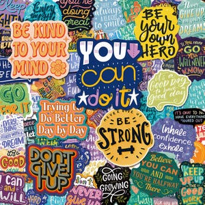 Può includere: Una collezione di adesivi in vinile colorati con citazioni e frasi motivazionali come Be Kind To Your Mind, You Can Do It, Be Strong e Never Give Up On Your Dreams. Gli adesivi mostrano vari caratteri, colori e forme.
