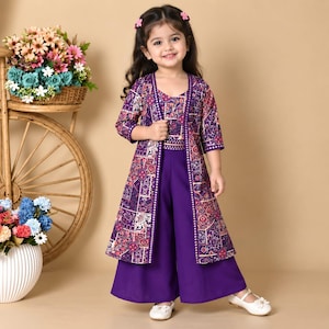 May include: A purple three-piece outfit consisting of a sleeveless top, wide-leg trousers, and a long-sleeved open jacket. The jacket and top feature a multi-colored geometric and floral pattern, while the trousers are a solid deep purple.