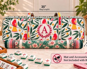 May include: A rectangular quilted bag featuring a white background with a pattern of red birds, green leaves, and yellow flowers. The center displays a red embroidered letter A within a wreath. It measures 35 inches long, 11 inches high, and 6 inches wide.