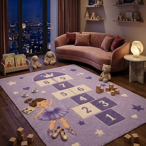 May include: A rectangular purple area rug featuring a hopscotch grid numbered one through nine, decorated with a ballerina illustration in a purple tutu, stars, and hearts. The rug has a textured pile surface and is placed on a wooden floor.