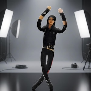 May include: A figurine of a performer with long black hair, wearing a black jacket and black pants with a gold belt. The figure has arms that transition into beige fabric sleeves, posed with arms raised and legs crossed in a dance stance.