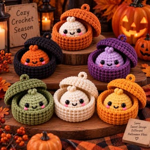 Peut inclure: Six contenants ronds au crochet avec couvercles, chacun contenant un petit personnage de boulette en peluche avec des yeux noirs et des joues roses. Les contenants sont orange, noirs, violets, vert olive, crème et jaunes, sur une surface en bois.