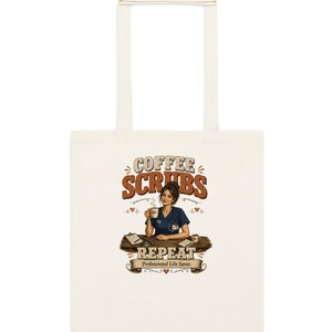 May include: A cream-colored canvas tote bag featuring a graphic print of a person in blue scrubs holding a coffee mug at a desk. The text reads COFFEE SCRUBS REPEAT and Professional Life Saver, accompanied by small heart and heartbeat line illustrations.