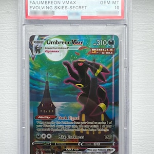 Op de afbeelding: Een Pokemon SWSH Evolving Skies #215 Umbreon VMAX ruilkaart in een PSA-houder. De kaart toont een gigantische Umbreon die onder een volle maan boven een gebouw staat, met de tekst Umbreon VMAX, Single Strike, Dark Signal en Max Darkness.