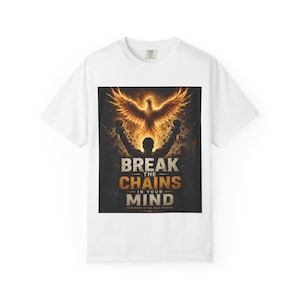 Könnte beinhalten: Ein weißes T-Shirt mit kurzen Ärmeln und einem Grafikdruck, der eine Silhouette zeigt, die Ketten sprengt, während ein feuriger Phönix darüber aufsteigt. Der Text lautet BREAK THE CHAINS IN YOUR MIND und YOUR MIND IS THE ONLY PRISON.