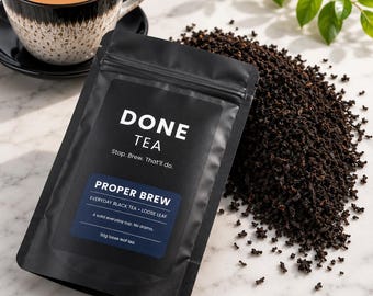 May include: A black resealable pouch of Done Tea labeled Proper Brew, Everyday Black Tea, Loose Leaf, 50g loose leaf tea, with a pile of dark loose tea leaves next to it and a ceramic cup filled with light brown tea in the background.