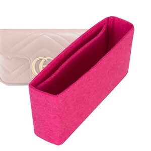Peut inclure: Un insert de sac en feutre rose avec deux compartiments. L'insert est conçu pour s'adapter à l'intérieur d'un sac à main afin d'aider à organiser le contenu.