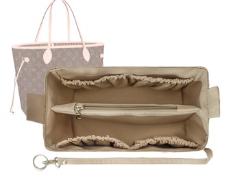 May include: Beige fabric handbag organizer with multiple compartments and a zippered pocket. The organizer has a detachable strap and a key ring.