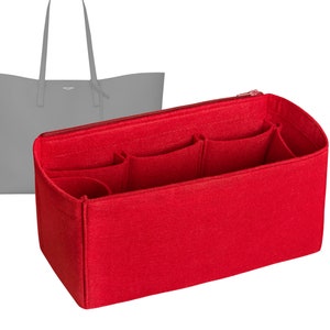 May include: A red felt handbag organizer with multiple compartments and a zipper closure. A gray tote bag is in the background. The organizer is designed to keep the contents of a handbag neat and organized.