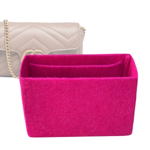 Peut inclure: Un organiseur de sac en feutre rose avec deux compartiments et un grand espace ouvert. L'organisateur est conçu pour s'adapter à l'intérieur d'un sac à main.