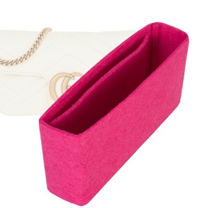 Peut inclure: Un insert de sac en feutre rose pour un sac à main. L'insert a deux compartiments et est conçu pour aider à organiser le contenu d'un sac à main.