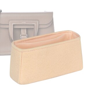 May include: A beige felt bag insert with a single divider. The insert is designed to fit inside a handbag to help keep it organised.