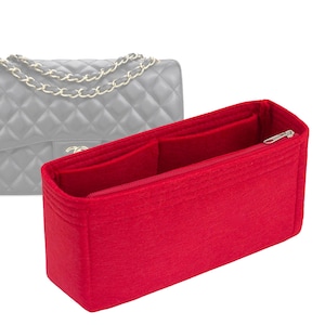 May include: Red felt bag organizer with multiple compartments and a zipper closure. The organizer is designed to fit inside a handbag.