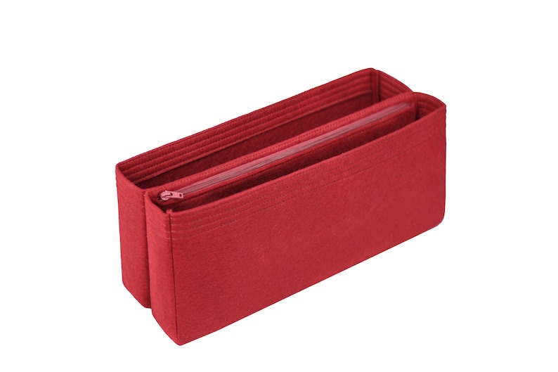 May include: Red felt bag organizer with a zippered compartment. The organizer has multiple compartments and is designed to fit inside a larger bag.