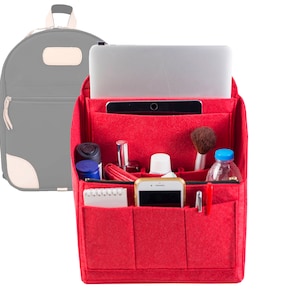 Puede incluir: Organizador de fieltro rojo con múltiples bolsillos para una mochila. El organizador incluye bolsillos para una computadora portátil, una tableta, un teléfono, bolígrafos y otros artículos.