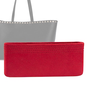 May include: Red felt bag insert for a tote bag. The insert has a rectangular shape and is made of a soft, red felt material.