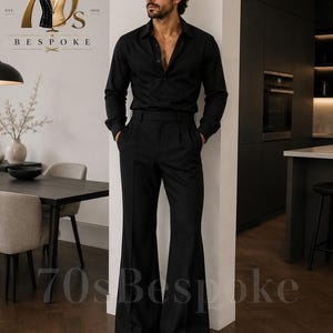 May include: A black long-sleeved button-down shirt and black high-waisted trousers with a wide-leg flare silhouette. The outfit is paired with black dress shoes. The image includes the text 70s BESPOKE EST. 1970 and 70s Bespoke.