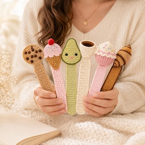 May include: A set of six crocheted bookmarks featuring various food-themed designs including a chocolate chip cookie, an ice cream cone, a green avocado with a face, a coffee cup, a pink cupcake, and a brown croissant, all with long flat stems.