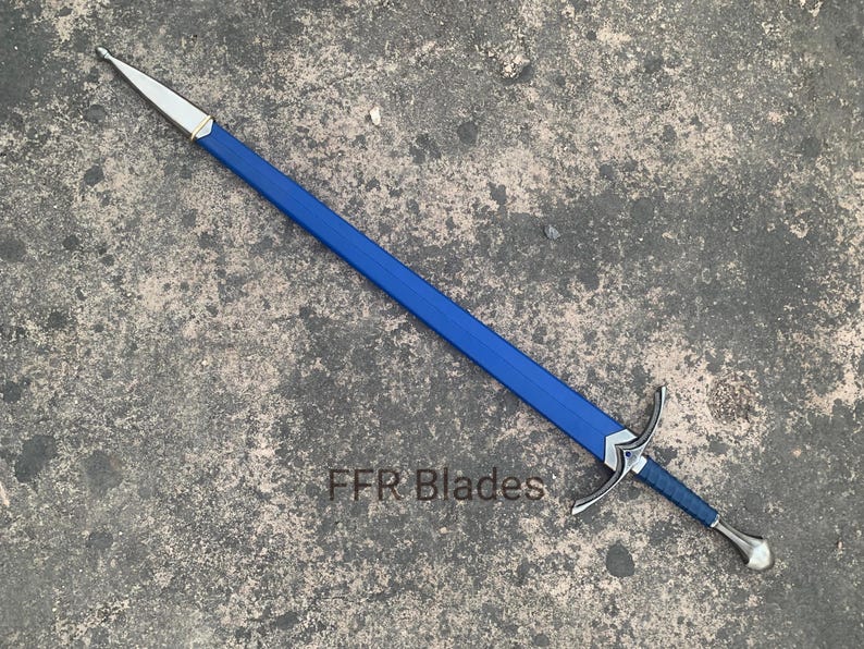May include: A longsword with a blue leather-wrapped scabbard and hilt, featuring a silver-toned metal pommel, crossguard, and chape. The text FFR Blades is visible near the crossguard on the blue scabbard of this sword.