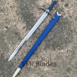 May include: A steel sword with a blue leather-wrapped grip, a silver crossguard, and a matching blue scabbard with silver metal fittings. The text FFR Blades is visible on the scabbard. The blade is double-edged with a central fuller.