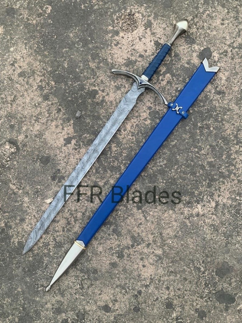 May include: A sword with a patterned Damascus steel blade, a blue wrapped grip, and a silver-toned crossguard and pommel. It is accompanied by a matching blue scabbard with silver-toned metal fittings. The text FFR Blades is visible.