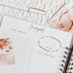 May include: A pregnancy journal with a white cover and black spiral binding. The cover has the text "I'm pregnant!" and a wreath with the words "Due Date". There are two photos on the page, one of a pregnancy test and one of a pregnant woman.
