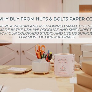 K&ouml;nnte beinhalten: Ein wei&szlig;er Schreibtisch-Organizer mit orangefarbener Schere, Stiften und Markern, neben einer Rolle wei&szlig;er Etiketten und gestapelten Versandkartons. Der Text auf dem Bild lautet: WHY BUY FROM NUTS & BOLTS PAPER CO? WE'RE A WOMAN AND MOM-OWNED SMALL BUSINESS.