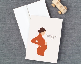 May include: A white card with a simple illustration of a pregnant woman in an orange dress. The text "Thank you" is written in cursive on the card.