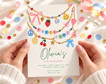 May include: A rectangular birthday invitation card featuring a watercolor illustration of gold chains adorned with colorful charms including a strawberry, dice, smiley face, peace sign, lemon, cherries, and bows. The text reads Olivia's 9th Birthday, Saturday 23rd August at 3pm, 44 Maple Avenue, Kew, RSVP to Emily 0400 123 456.