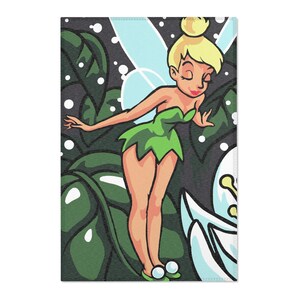 May include: A rectangular print featuring a cartoon fairy with blonde hair in a bun, wearing a green dress and light blue wings. The fairy is positioned among large dark green leaves and white circular sparkles, with a large white flower in the corner.