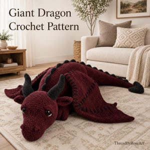 Peut inclure: Une grande peluche dragon au crochet de couleur bordeaux foncé avec des cornes noires, des bords d'ailes noirs et une pointe de queue noire. Le texte Giant Dragon Crochet Pattern est visible en haut à gauche et ThreadByRoseArt en bas à droite.